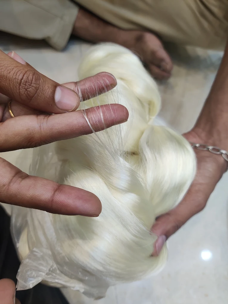 Raw pure silk yarn held in the weaver's hands
